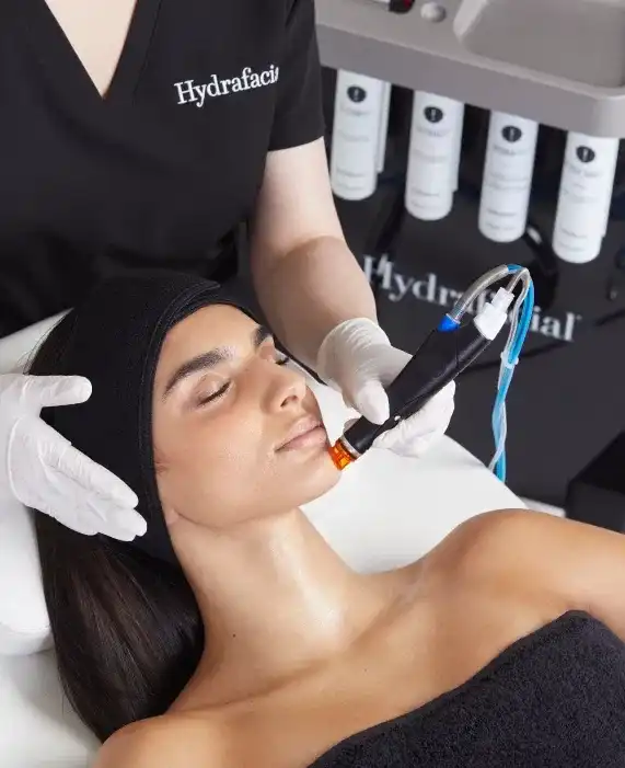 Person receiving a Hydrafacial treatment in a spa setting.